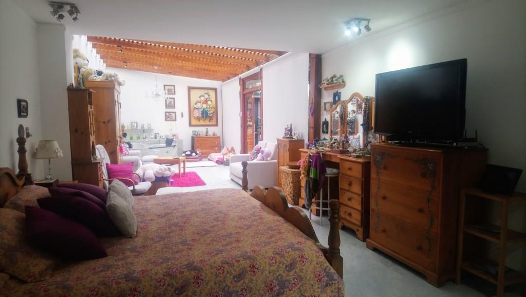 Dormitorio con cama y mobiliario de madera.