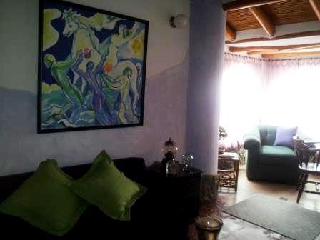 Sala con sofá y cuadro decorativo en la pared.