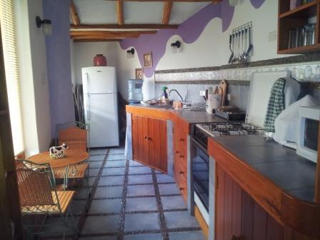 Cocina con mesón y gabinetes de madera.