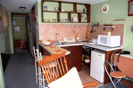 Cocina-comedor con barra y sillas altas.